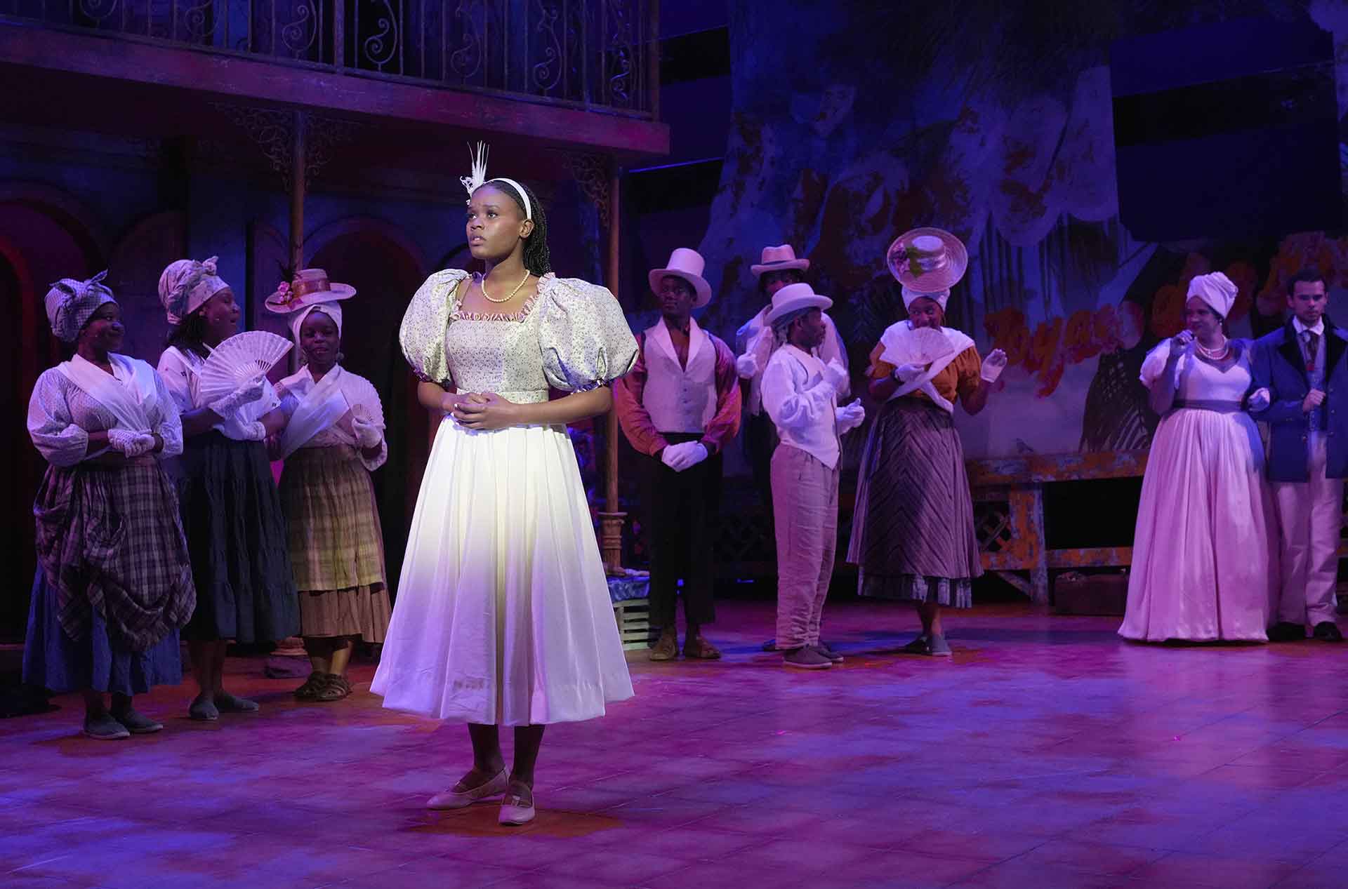 A person looking off into the distance with the ensemble behind.