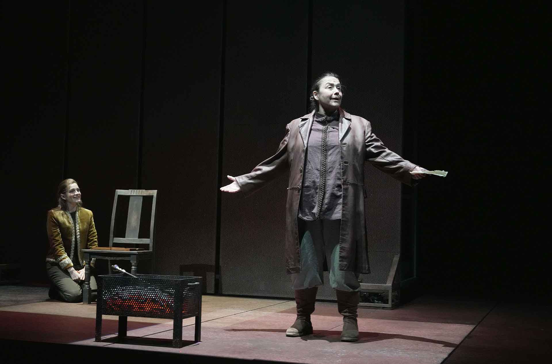 Person standing with arms wide while another person looks at them from behind.