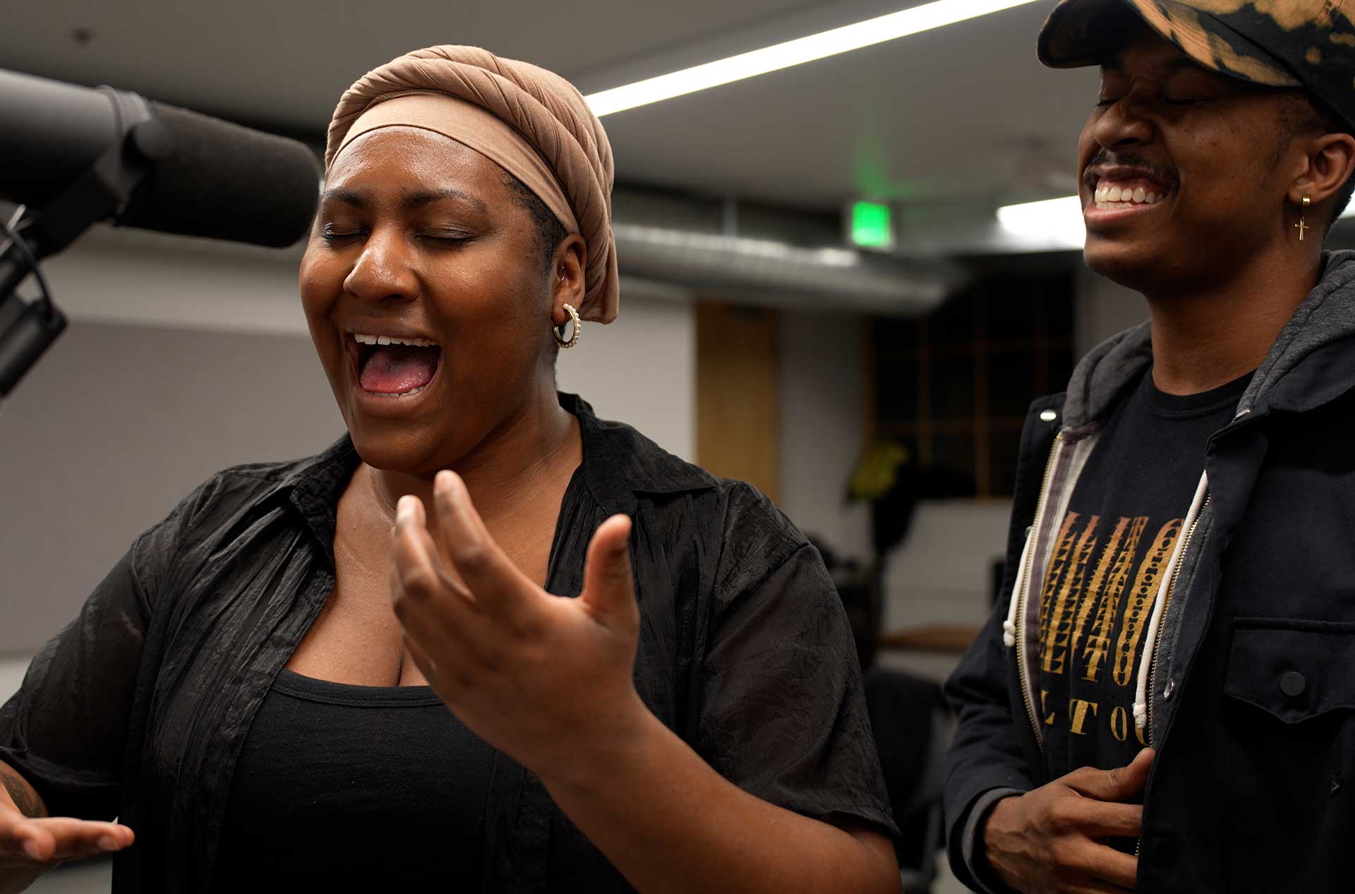 A person singing with another person standing beside them.