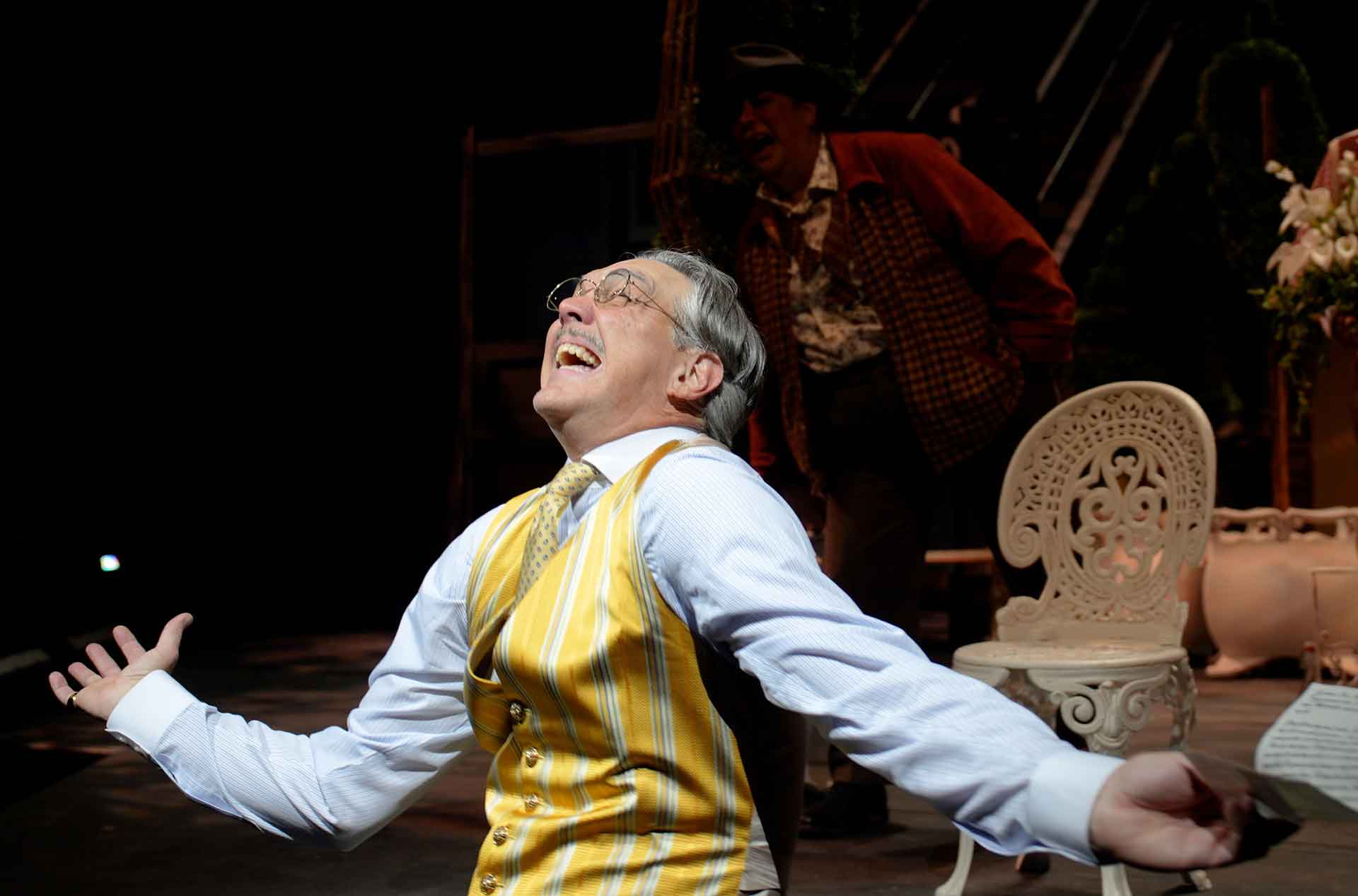 A person laughing and dancing with a few others standing behind.