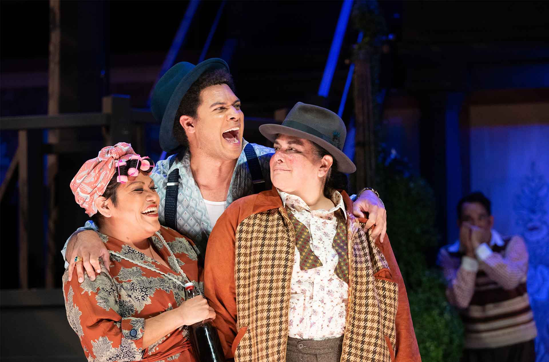 Two people standing with a third persons arms around them.