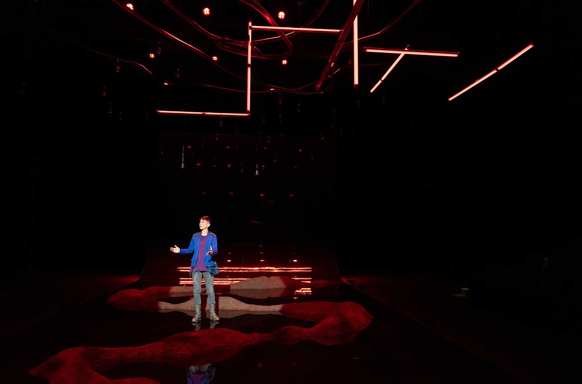 A person standing on the stage looking out toward the audience. 