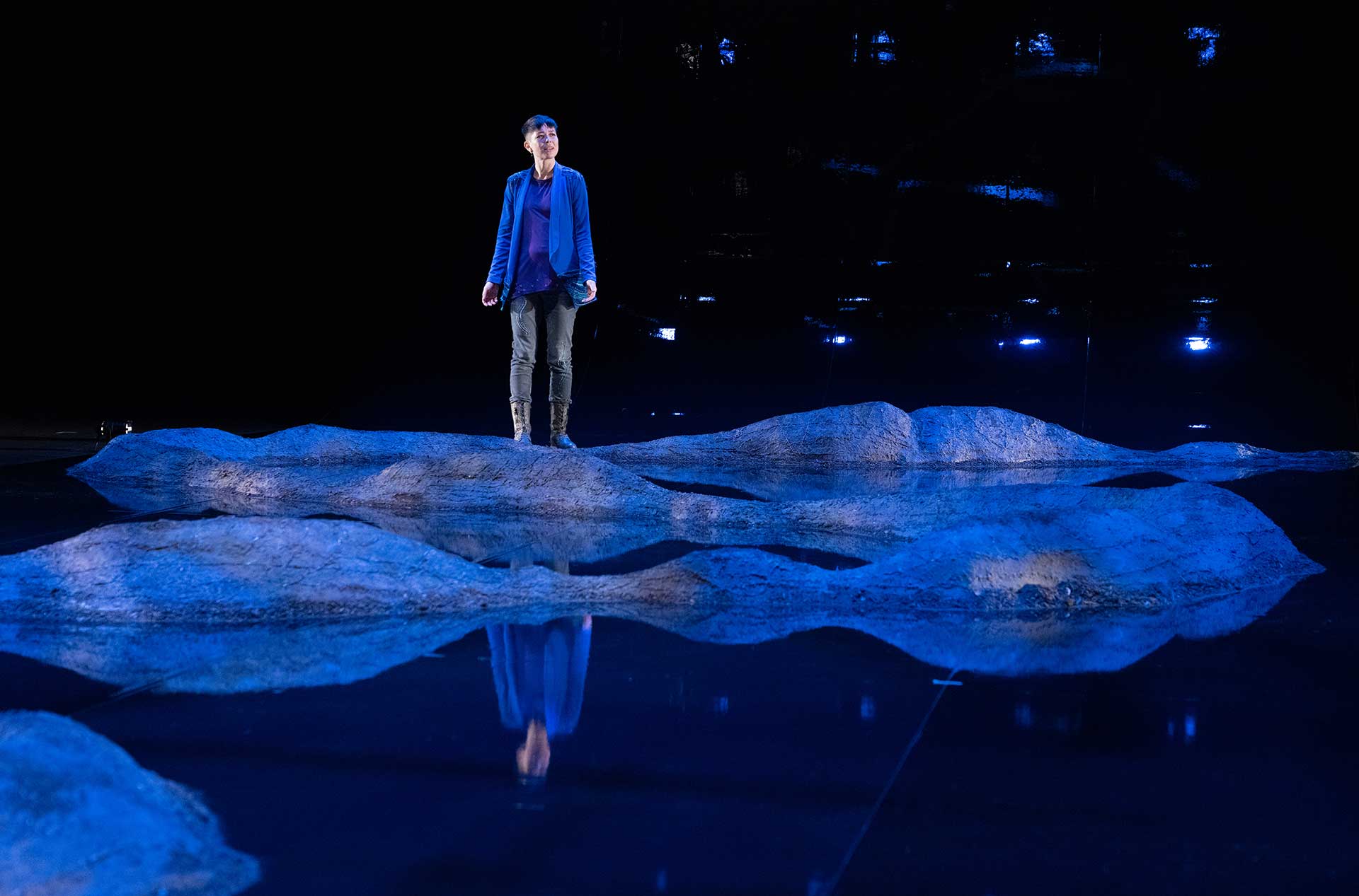 A person standing on the stage looking out toward the audience. 