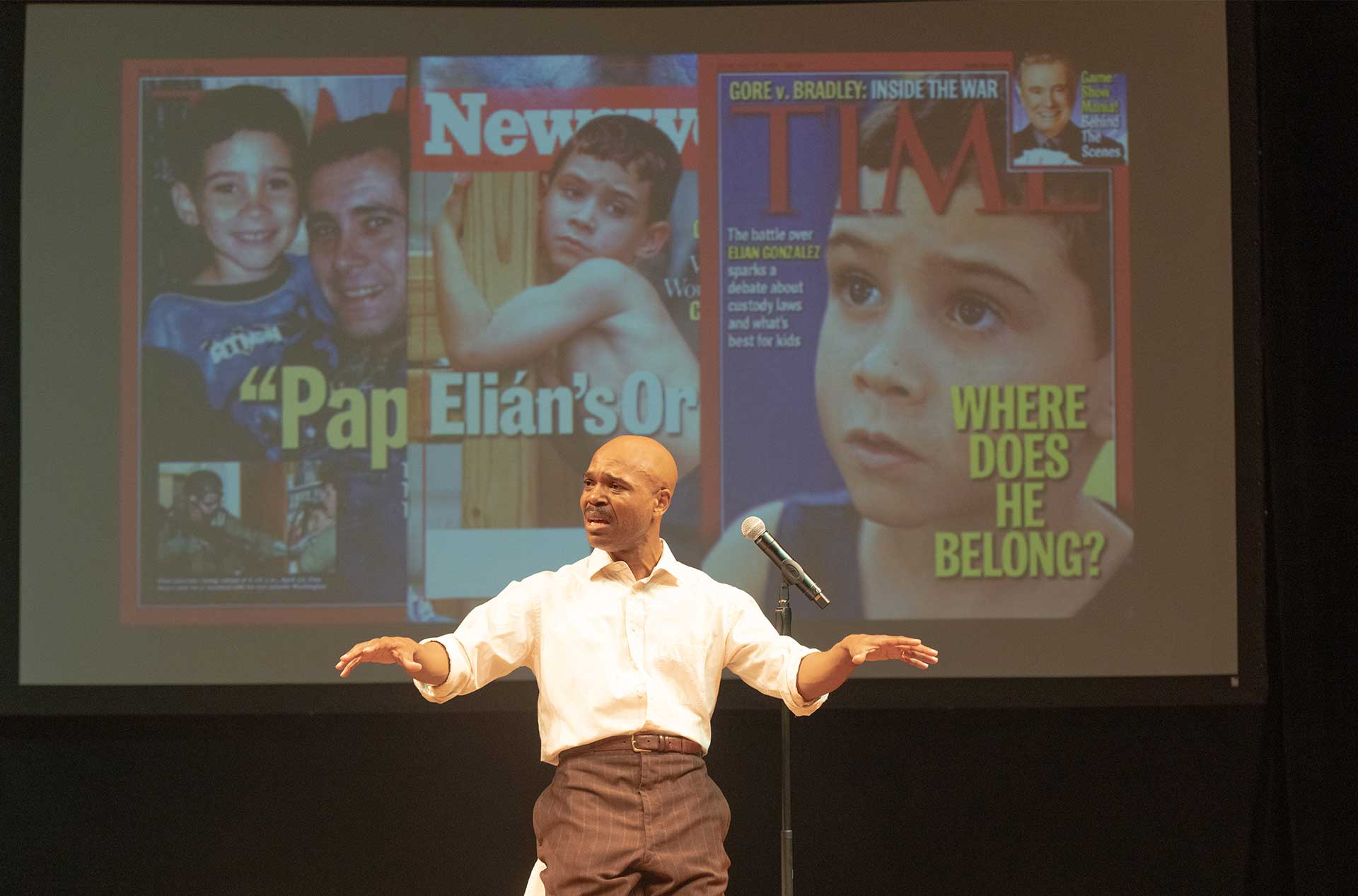A person standing in front of a projection of magazines covers.