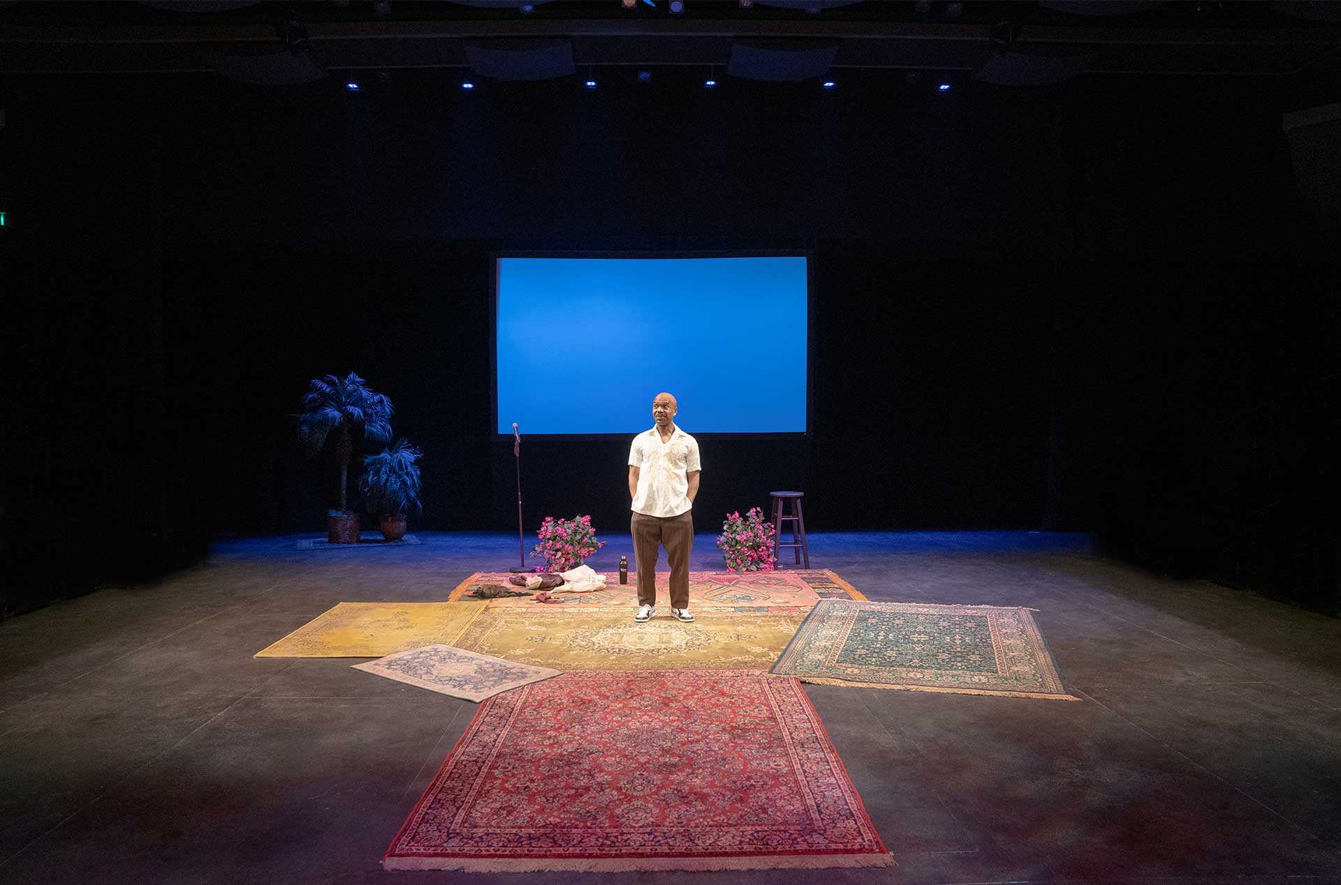 A person in the distance standing in front of blue screen.