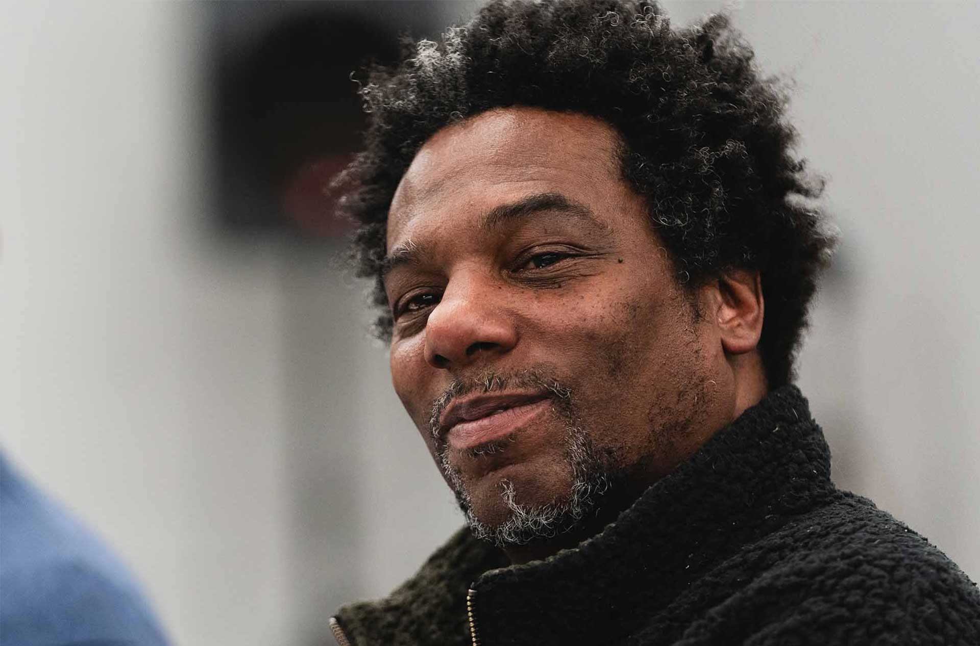 Close-up of a person with short hair and a relaxed expression, looking off to the side.