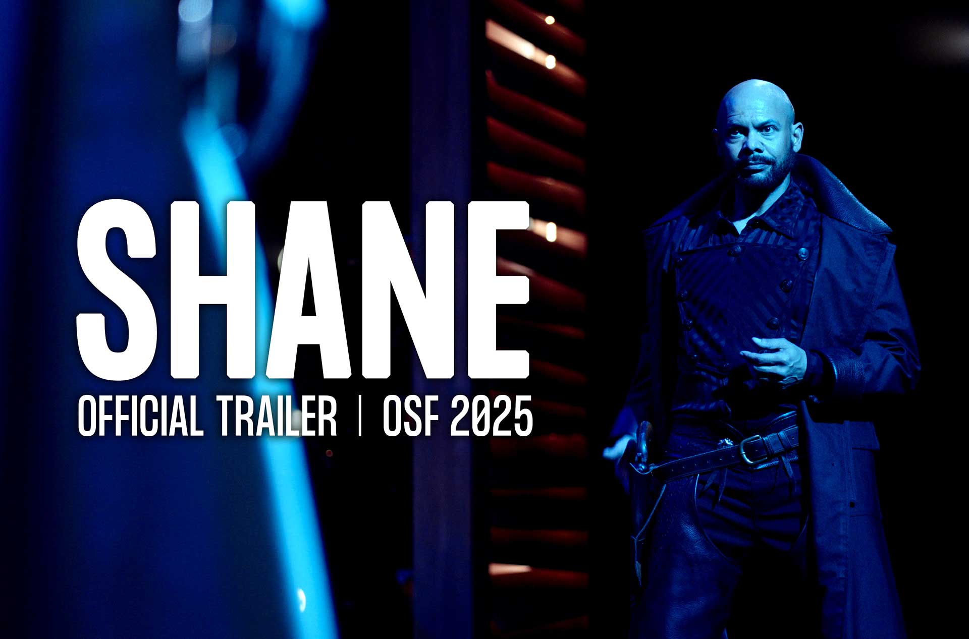 A person in a dark, dramatic costume stands under blue lighting, holding a weapon. The image features bold text reading "SHANE" with a subtitle stating "Official Trailer | OSF 2025."