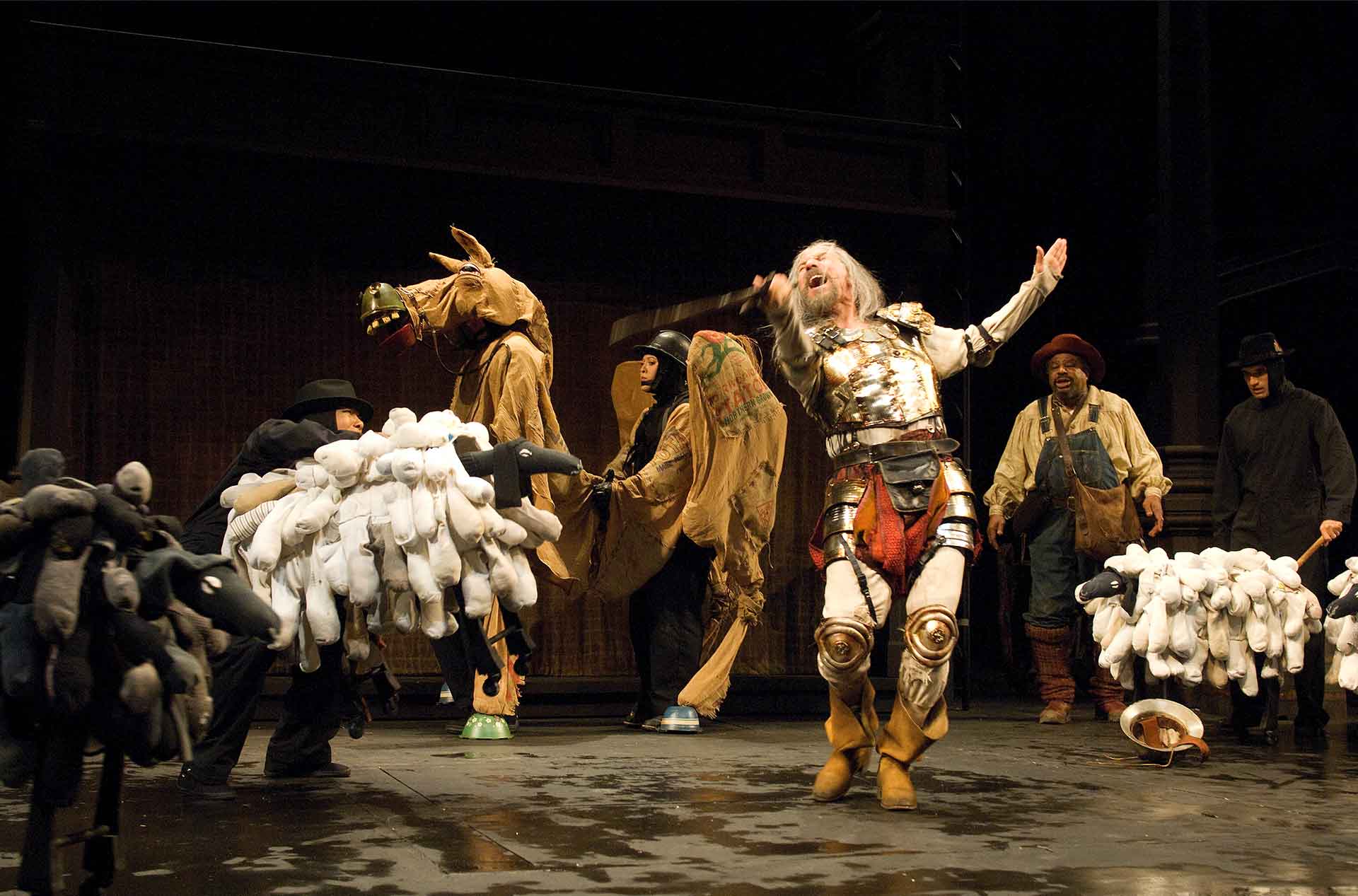Person standing in front of fake horses holding out a sword.