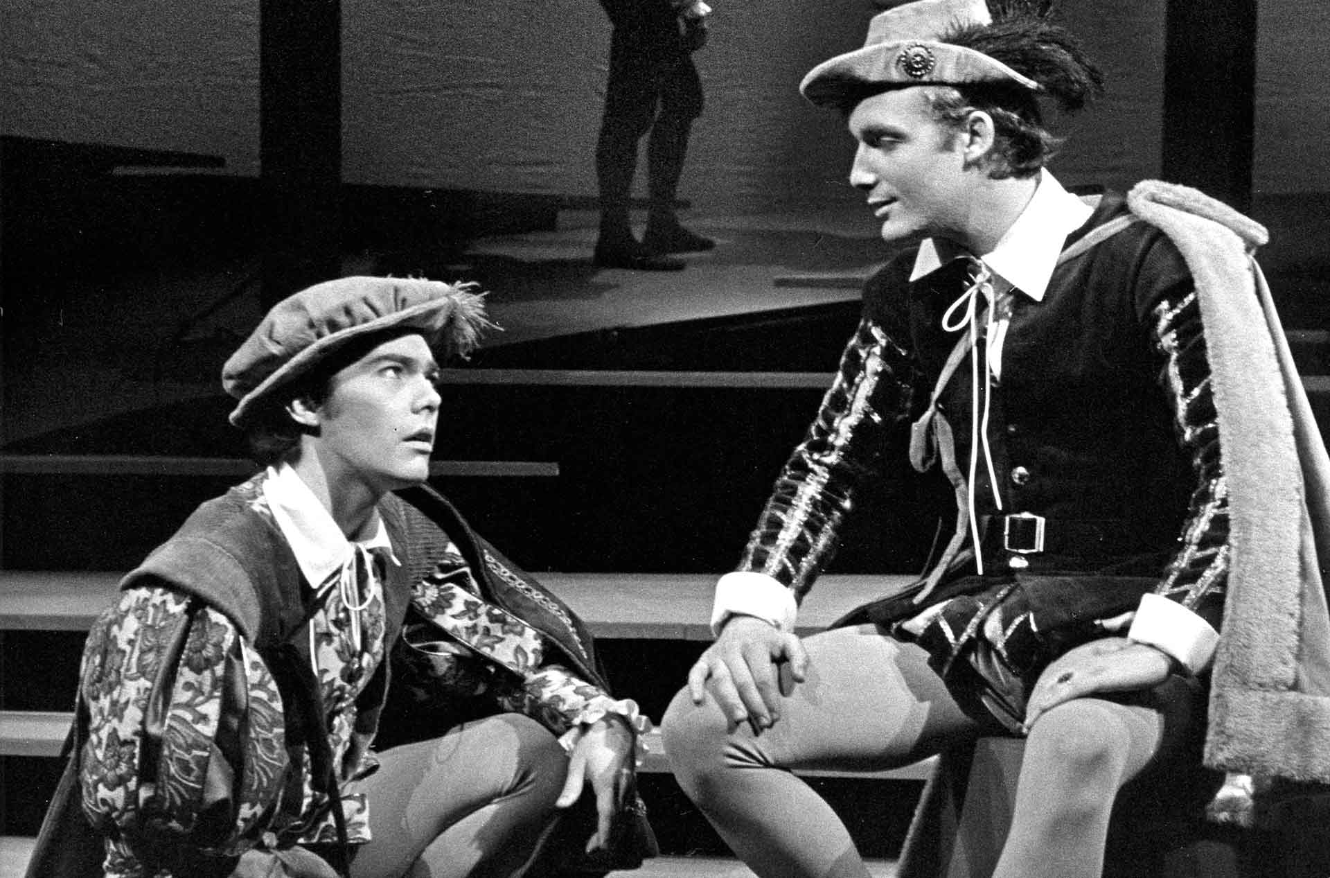 Two people sitting next to each other and looking at each other.